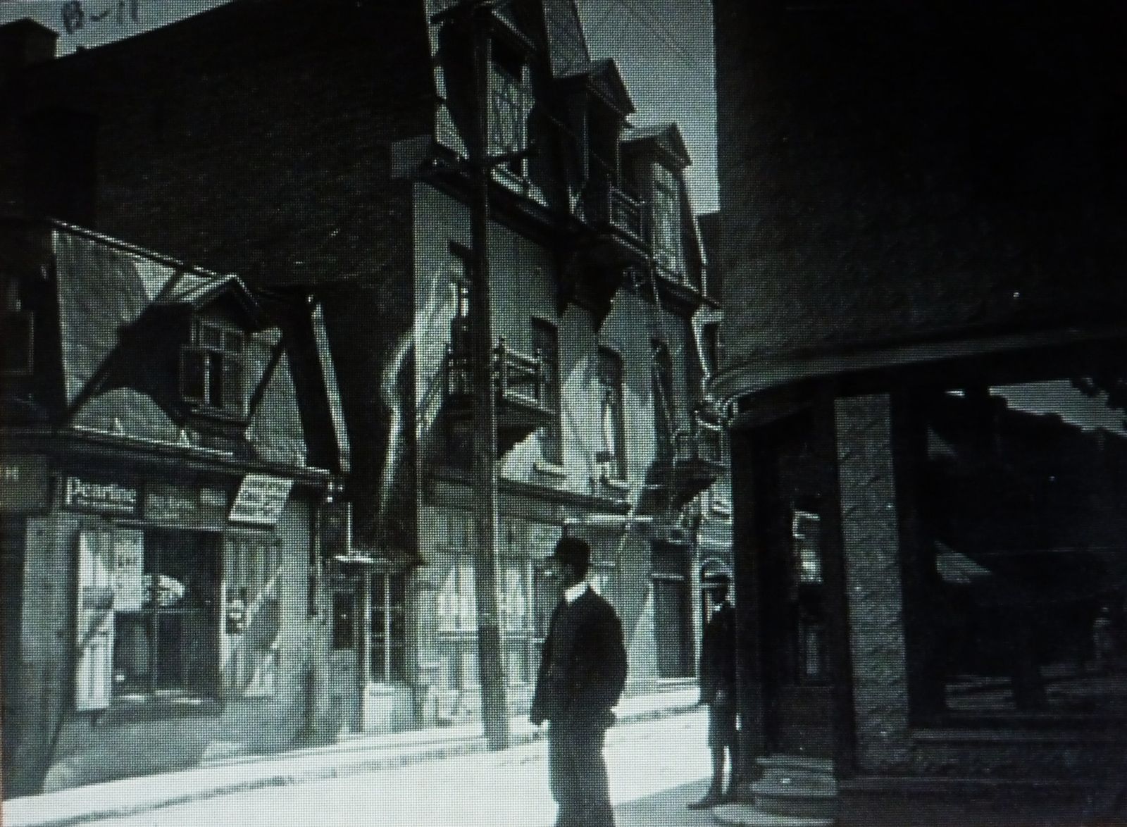 A street scene in Montreal's Jewish immigrant quarter, 1909, with period shopfronts and pedestrians.